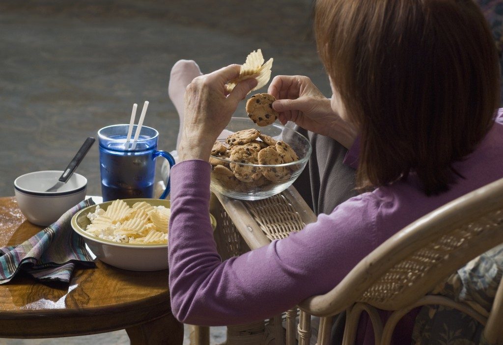 Middle-aged woman eating junk food