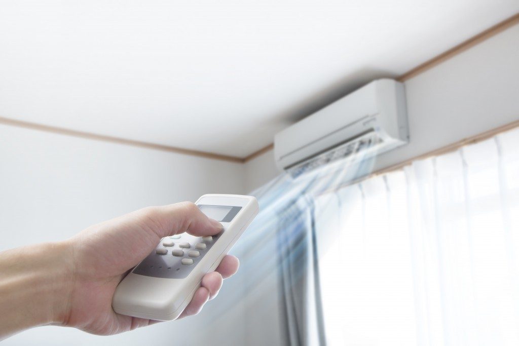person adjusting air conditioning temperature