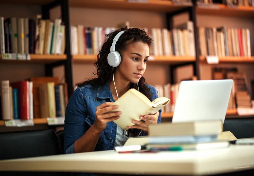 woman inside the library studying with her laptop