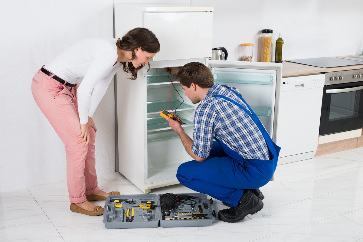 Female getting her fridge fixed