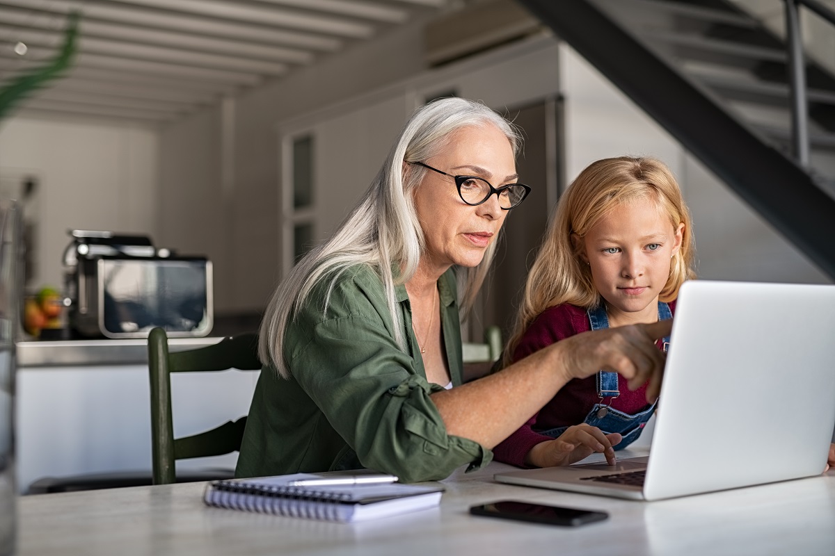 Senior woman and child studying on laptop