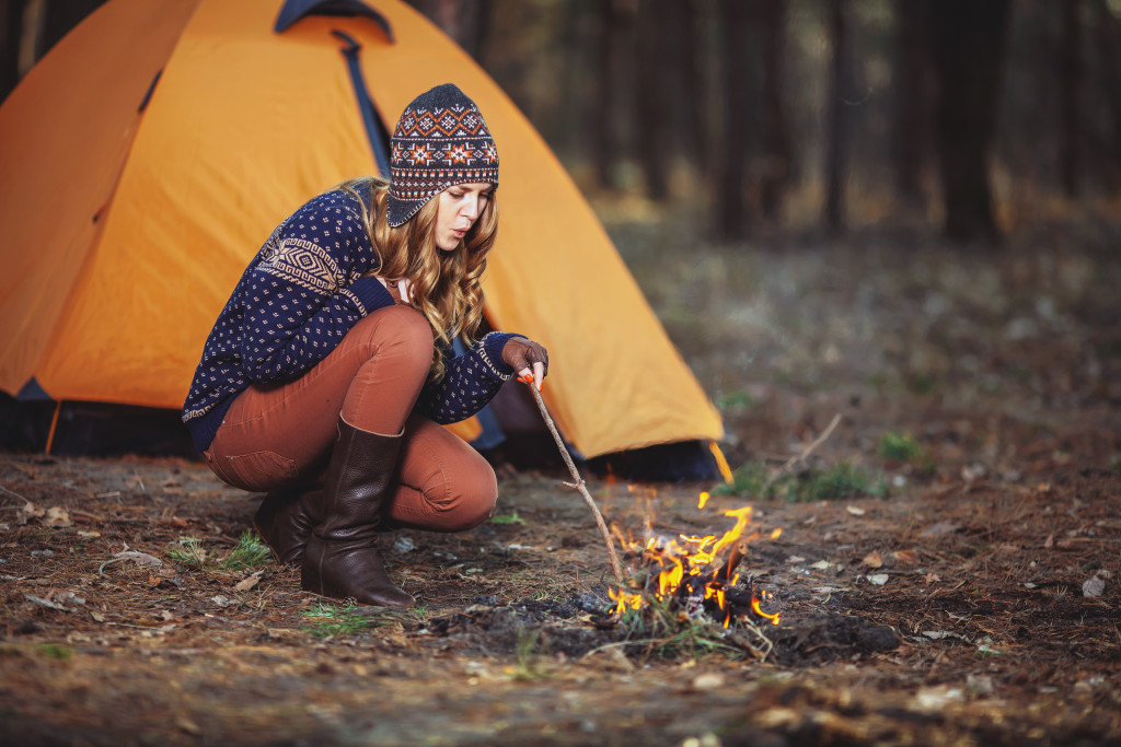 Female making fire in camping site