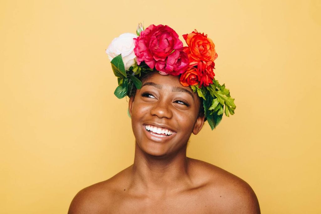 black woman wearing flower crown with perfect teeth
