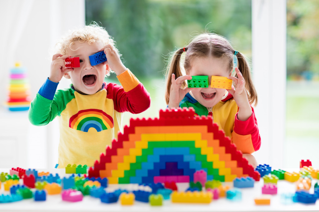 Two kids playing with colorful building blocks