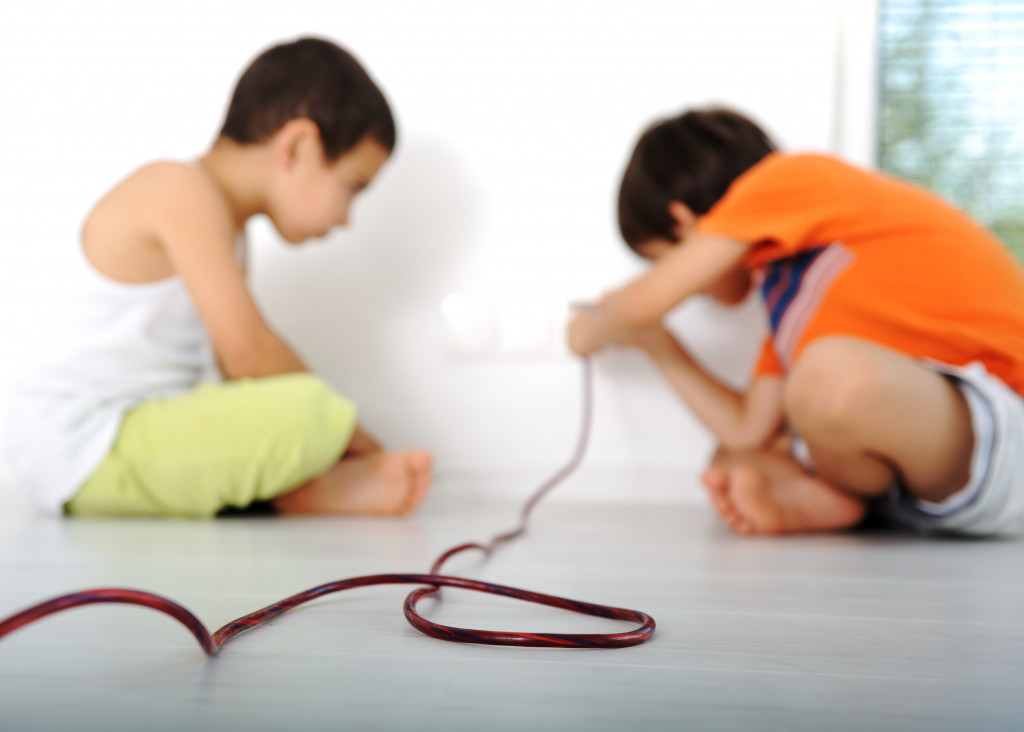 children holding electric wiring