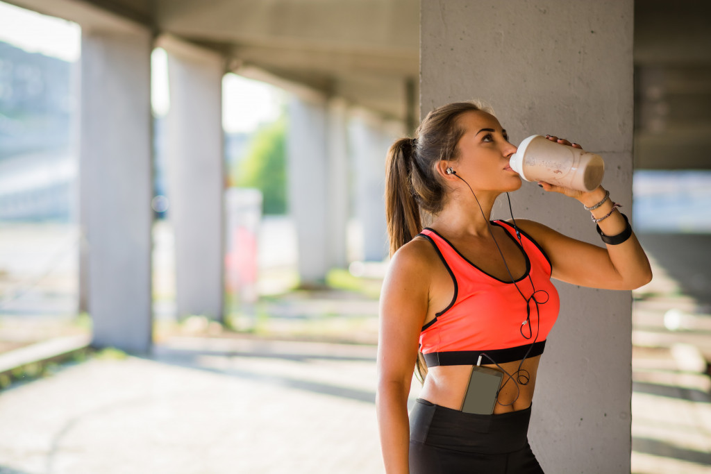 woman drinking protein shake after exercise