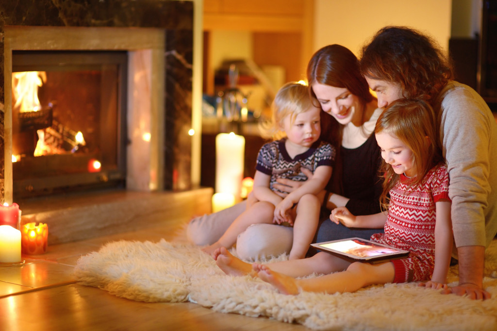 A happy family bonding on the floor in front of the fire place during the holidays