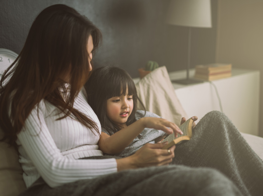 mother reading a story to her daughter at bedtime