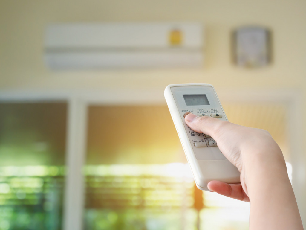 person using remote control to set the air conditioning system