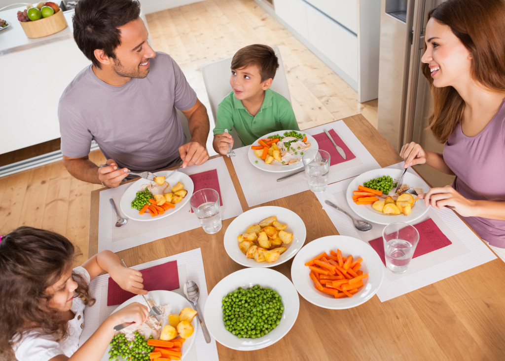 family smiling around healthy meal in kitchen or dining room