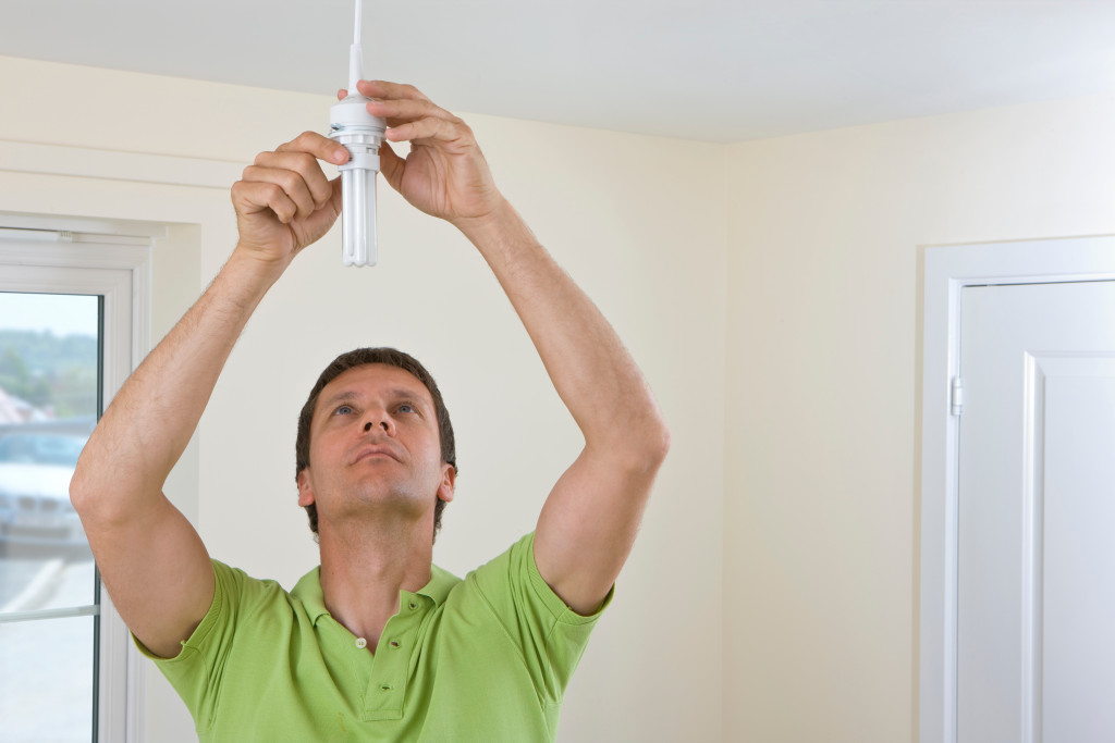 A man installing a lightbulb