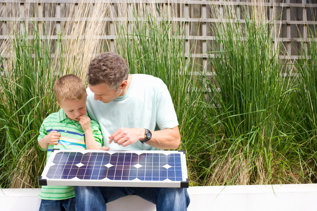 A father showing his some a small solar panel to be used for their home