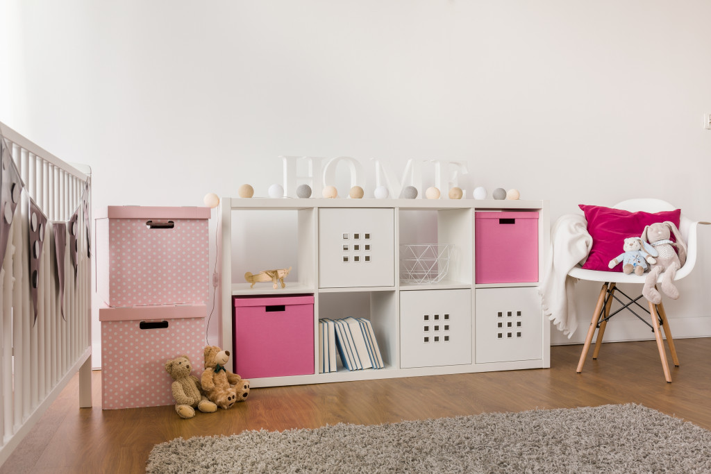 a pink themed home nursery with storage