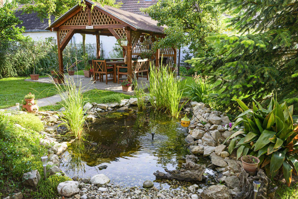 Home garden with a pond and bench where the family can relax.