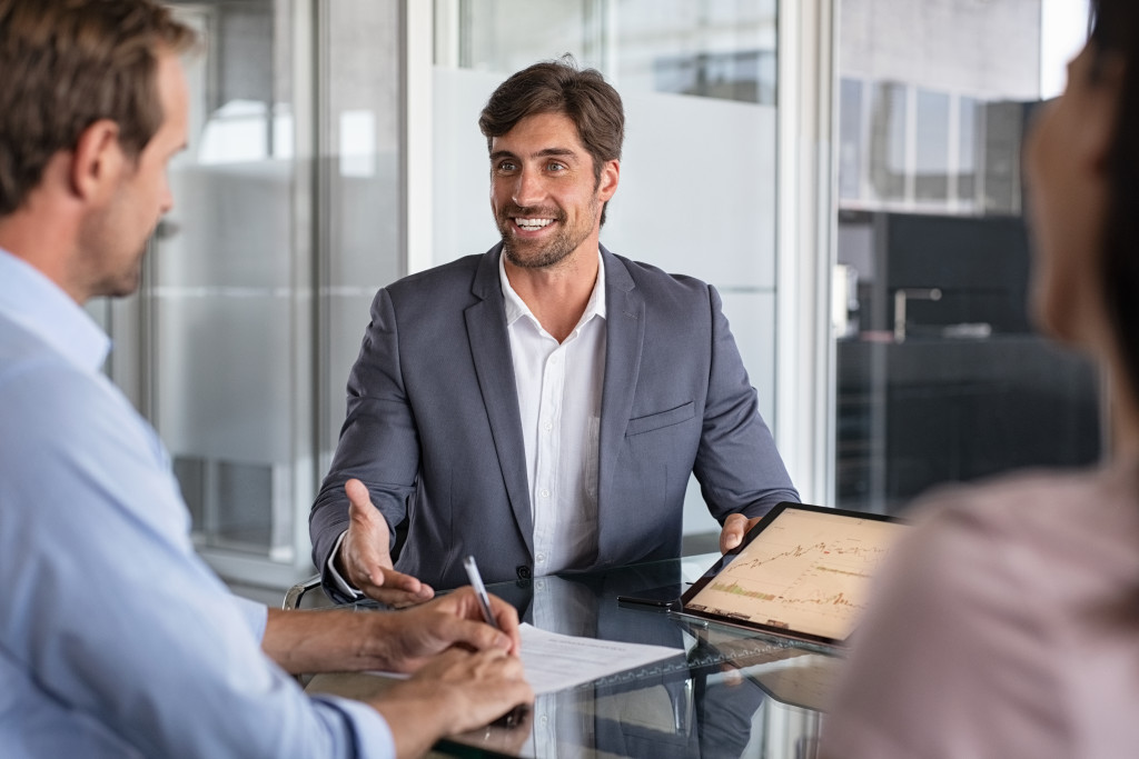 male wealth advisor talking to a couple in the office