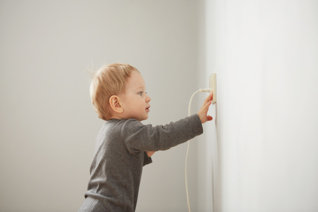 A kid touching an electrical outlet