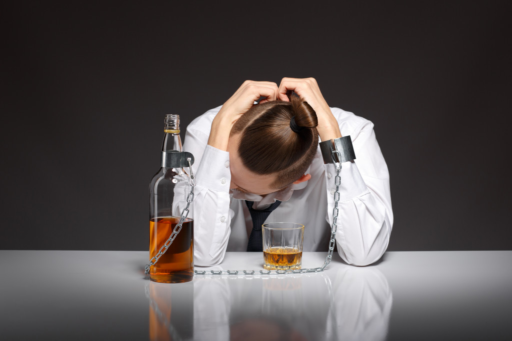 man drinking alcohol chained