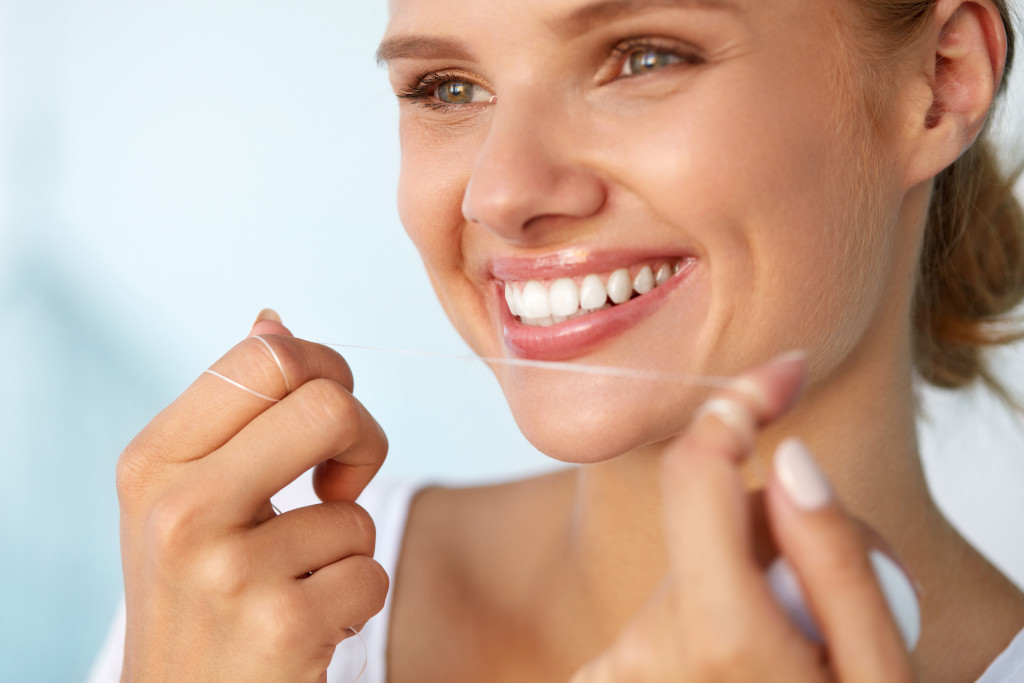 A woman holding a dental floss