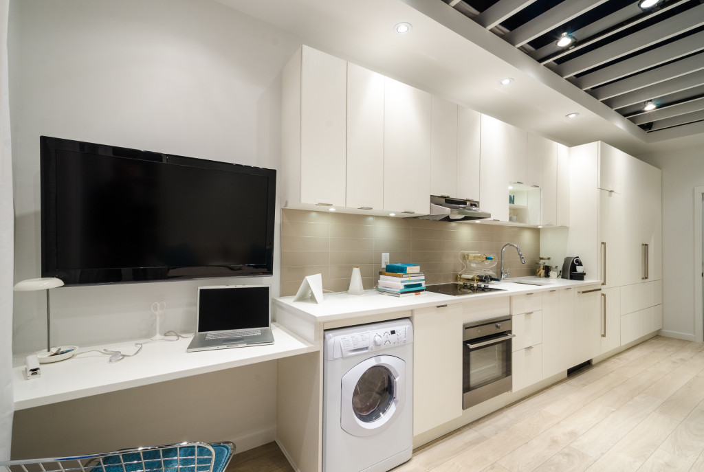 modern kitchen in luxury home with TV and laptop at the side