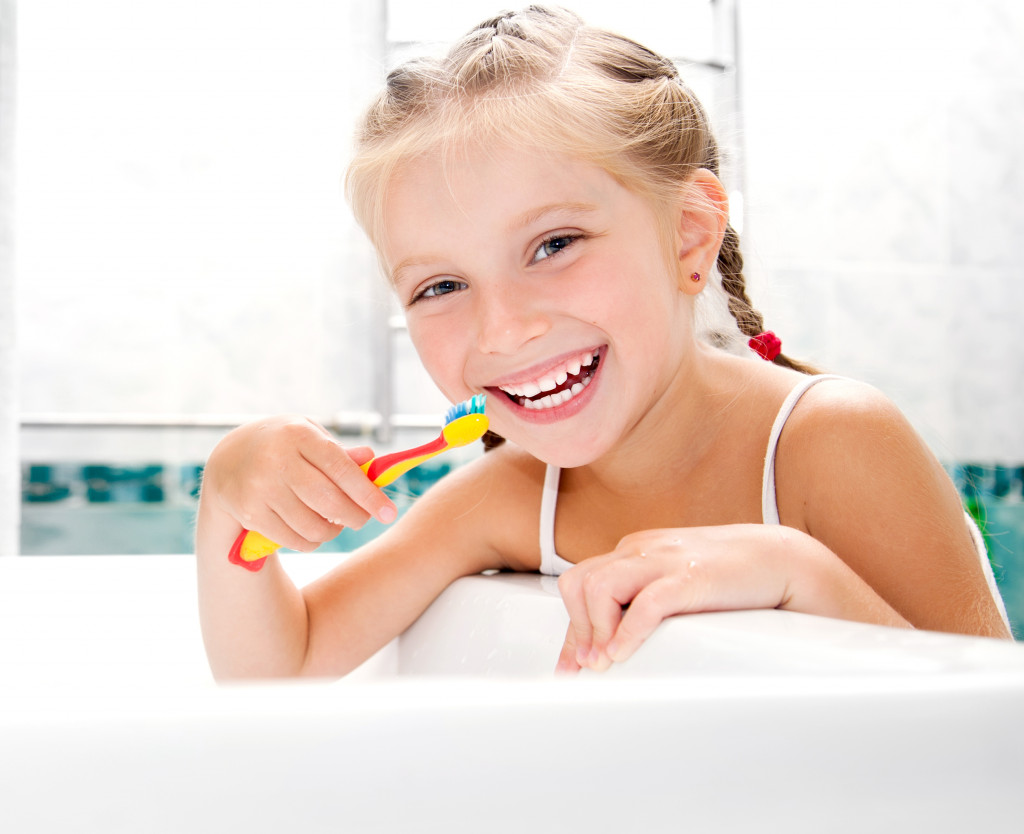 Little girl brushing her teeth in the bathroom.