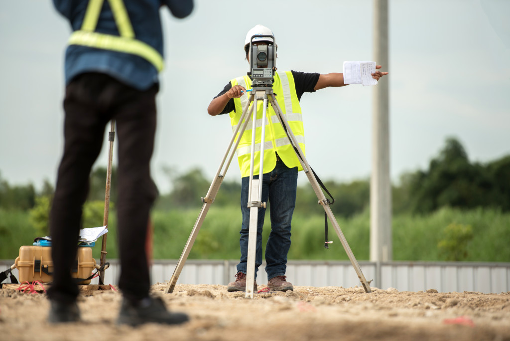 professionals checking land size using equipment