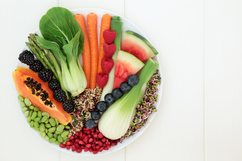 Fruits and vegetables on a plate placed on the dinner table.