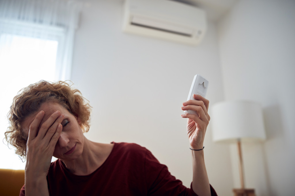 woman holding ac remote