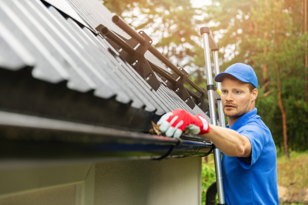 man on a ladder cleaing gutters