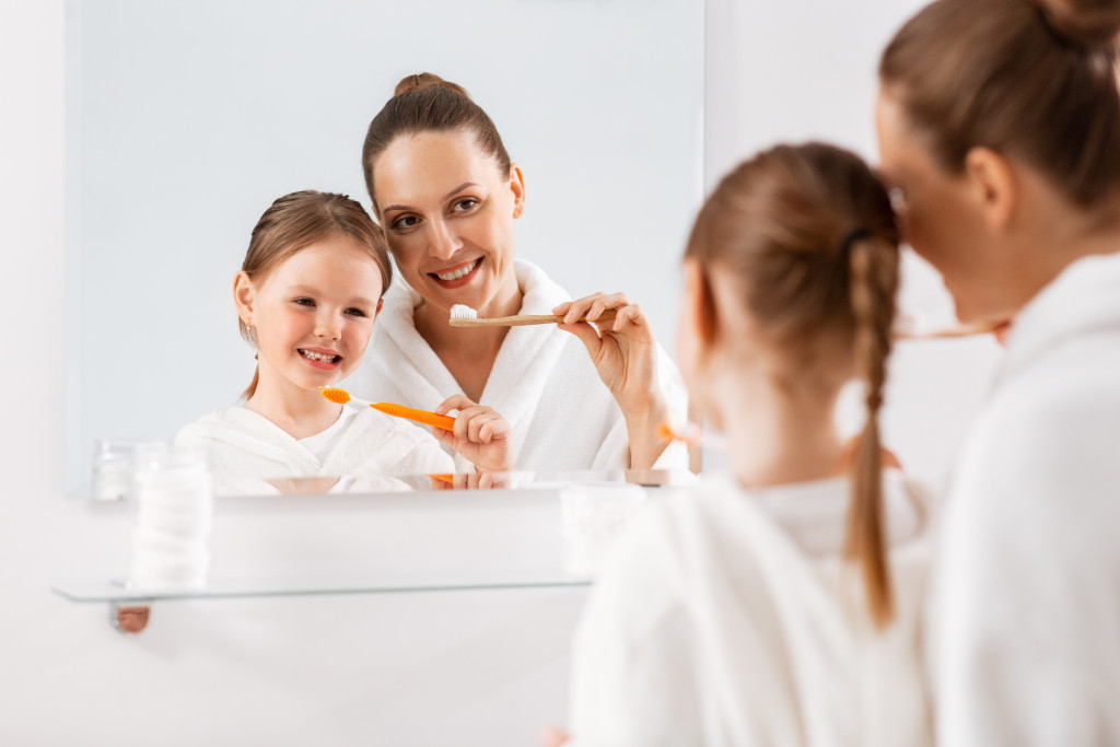 mom in the bathroom with kids brushing their teeth