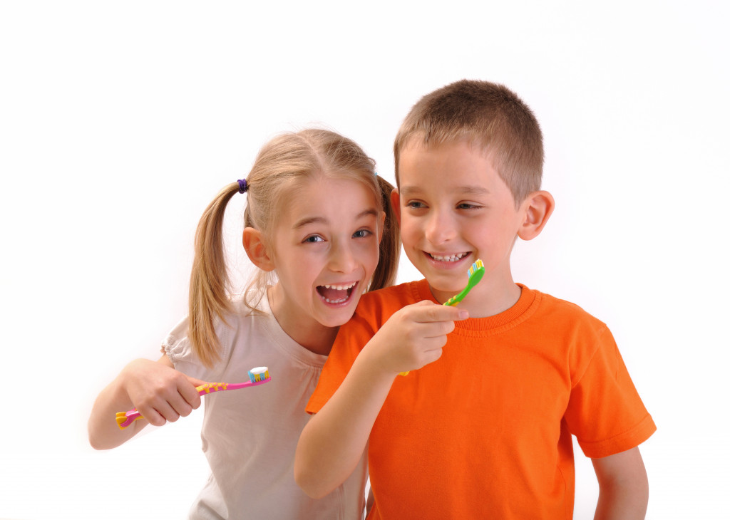 siblings with colored toothbrushes