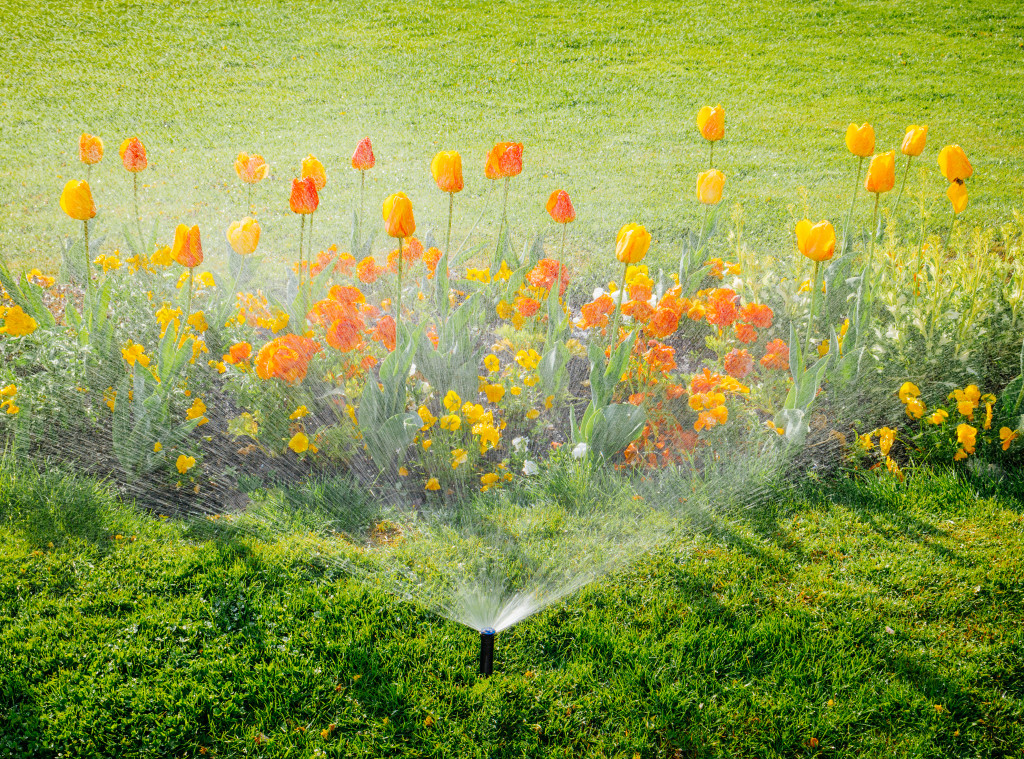 Garden bed with flowers and a sprinkler