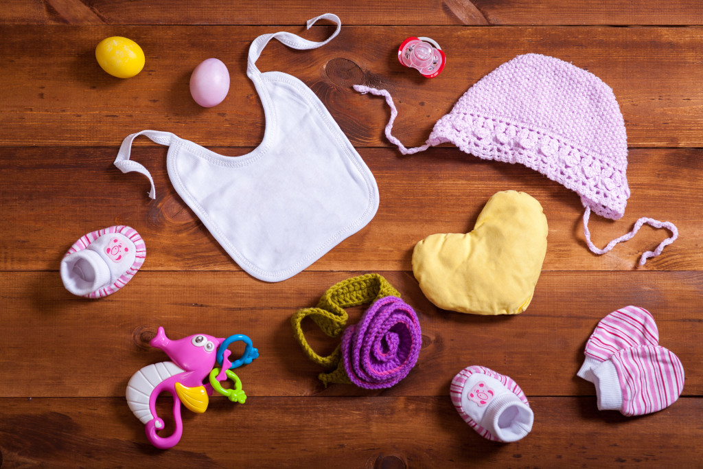 baby girl essentials sprawled out in a wooden background