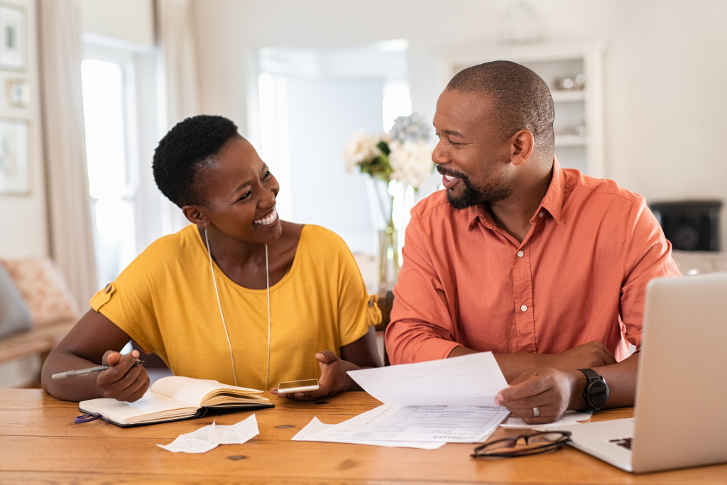 couple smiling while budgeting together in the living room