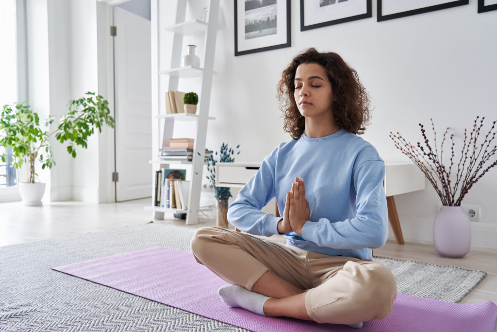 Teenage girl practicing yoga at home.