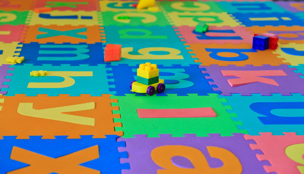 A playroom with toys and foam puzzles on the floor