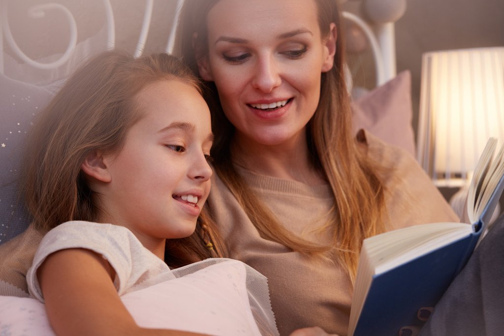 mom reading a book with her daughter