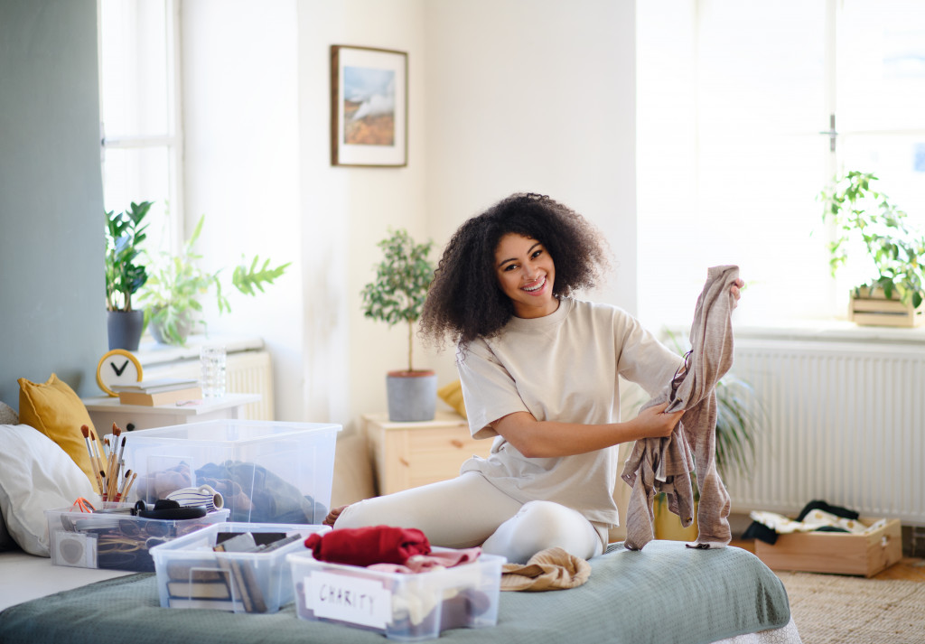 woman in her bedroom decluttering her items