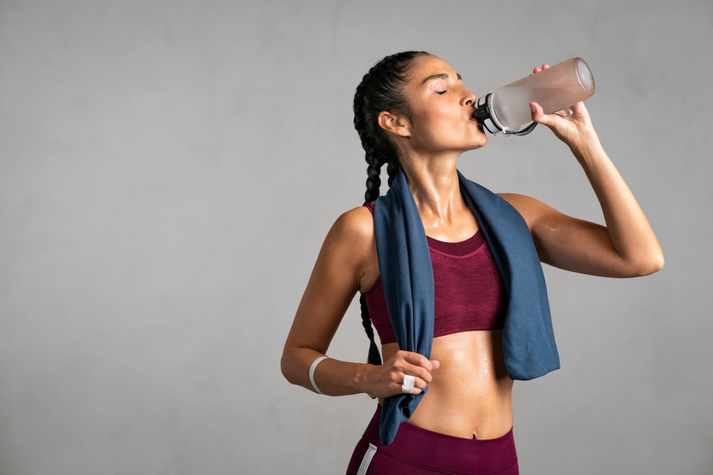 woman drinking water after a workout